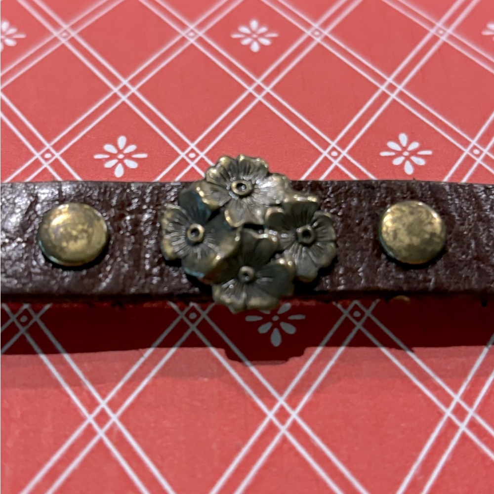 Leather cuff bracelet with brass detail.
